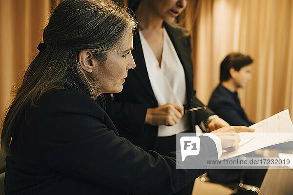 Businesswoman discussing over legal document with female lawyer in office