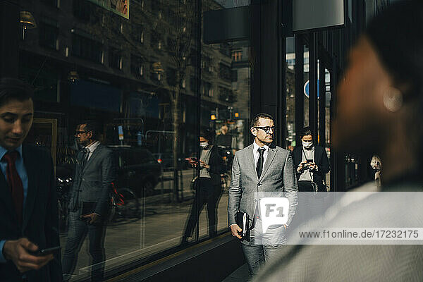 Businessman with hand in pocket on sunny day during pandemic