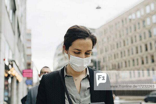 Unternehmerin mit Gesichtsschutzmaske in der Stadt