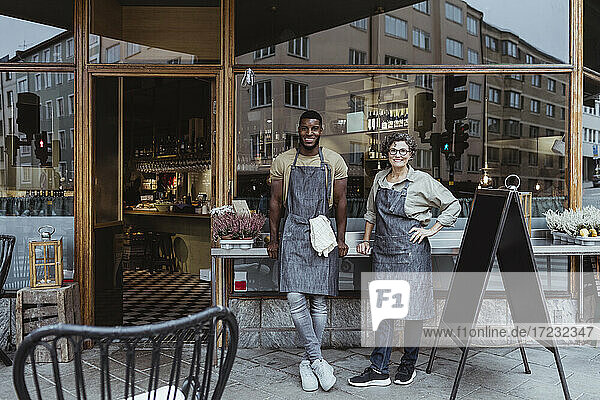 Portrait of smiling male and female coworker outside deli store