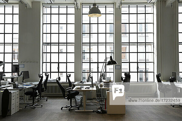 Interieur eines kreativen Büros mit Schreibtischen und Stuhl