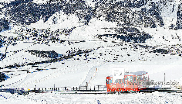 Tourists enjoying the journey on funicular in the snowy landscape  Muottas Muragl  Samedan  Engadine  Graubunden  Switzerland  Europe