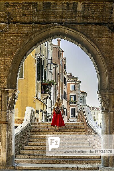 Junge Frau mit rotem Rock auf Treppe  Torbogen  Mercato di Rialto  Venedig  Venetien  Italien  Europa