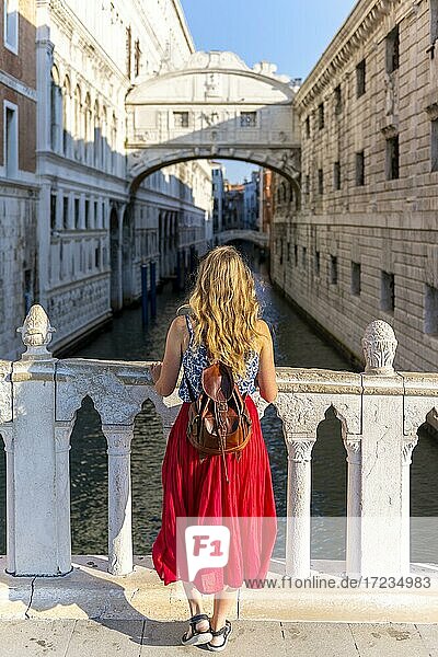 Junge Frau mit rotem Rock  Touristin auf einer Brücke über dem Rio di Palazzo  hinten Seufzerbrücke  Venedig  Venetien  Italien  Europa