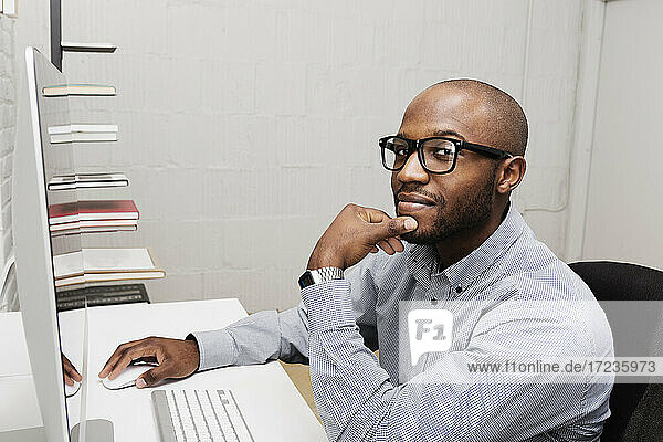 Portrait of young man using computer in design office