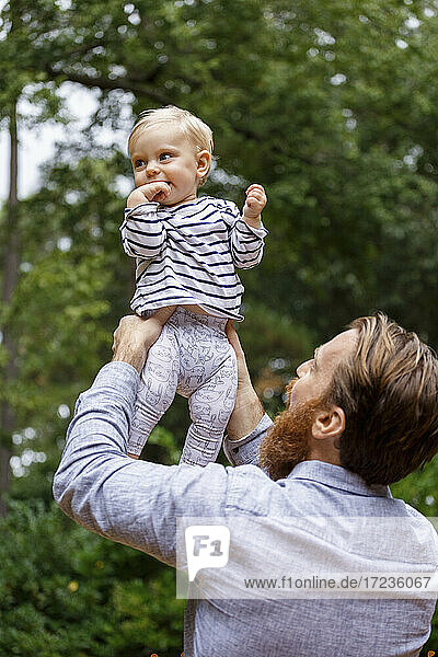 Father holding baby girl in air  outdoors