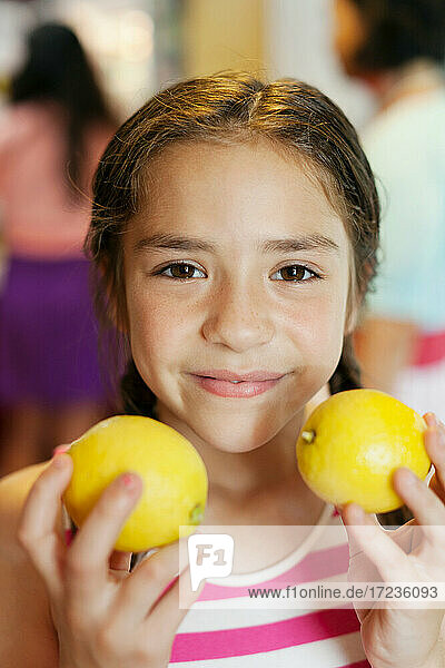 Mädchen hält zwei Zitronen