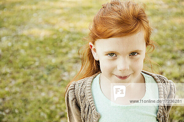 Portrait of red haired girl in park