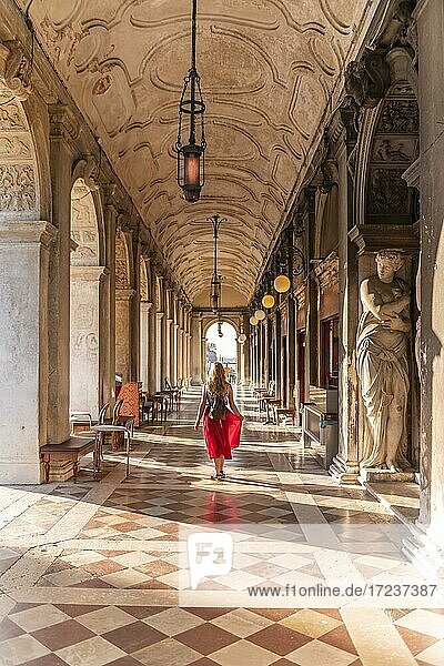 Junge Frau  Touristin läuft unter Arkaden am Markusplatz  Venedig  Venetien  Italien  Europa