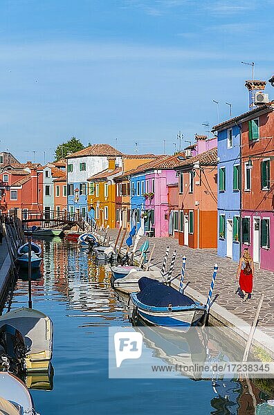 Junge Frau vor bunten Häusern  Kanal mit Booten und farbenprächtigen Häuserfassaden  Insel Burano  Venedig  Venetien  Italien  Europa