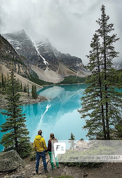 Couple looking over lake  clouds hanging between mountain peaks  reflection in turquoise glacial lake  Moraine Lake  Valley of the Ten Peaks  Rocky Mountains  Banff National Park  Alberta Province  Canada  North America