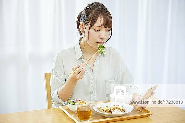 Junge Japanerin genießt das Essen zu Hause