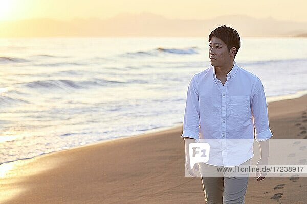 Junger japanischer Mann am Strand