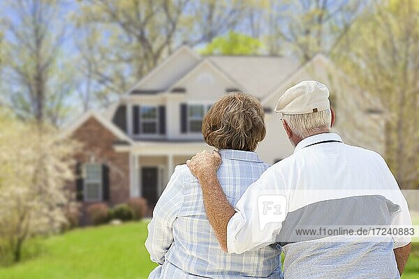 Glückliches Seniorenpaar von hinten mit Blick auf die Haus