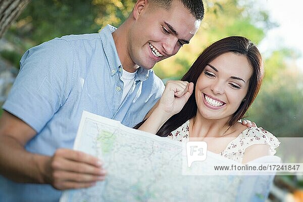 Glückliches gemischtrassiges Paar  mit Landkarte im Freien