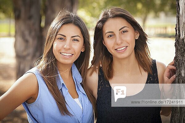 Two beautiful mixed-race twin sisters portrait outdoors