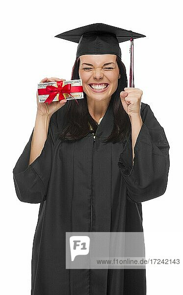 Happy female graduate in cap and gown holding stack of gift wrapped hundred dollar bills isolated on a white background