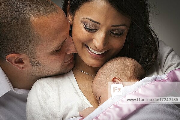 Glückliche junge attraktive gemischtrassige Familie mit neugeborenem Baby