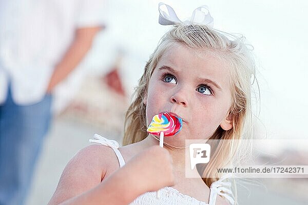 Nettes kleines Mädchen genießt ihre Lutscher draußen am Strand