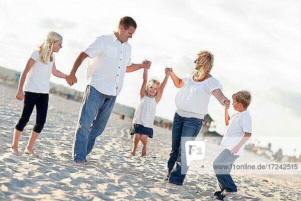 Adorable kleines Mädchen schwingt mit ihren Eltern und Familie am Strand