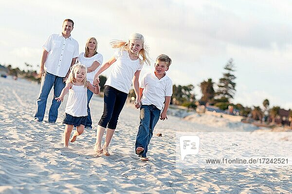 Adorable caucasian family on a walk at the beach
