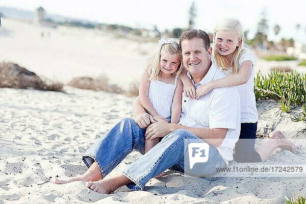 Hübscher Papa und seine süßen Töchter am Strand