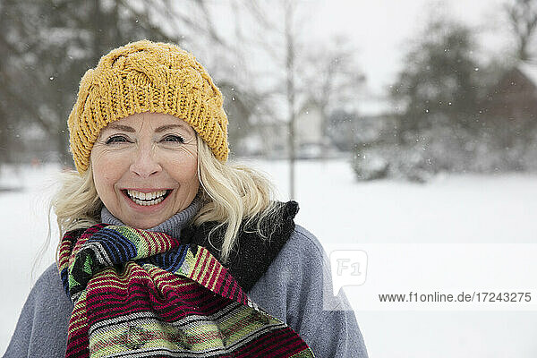 Smiling senior woman wearing knit hat at park