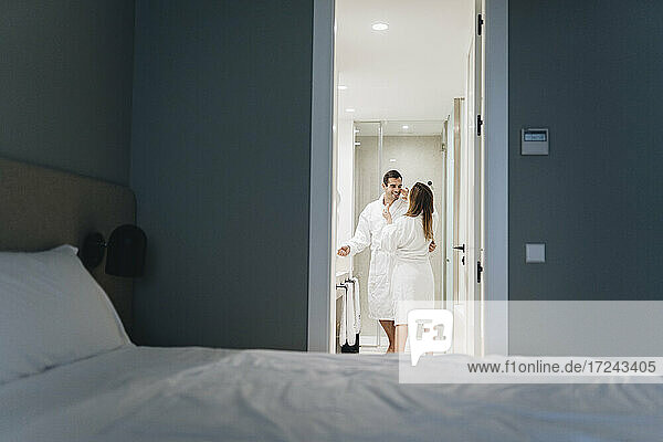 Couple in bathrobe standing in bathroom at hotel