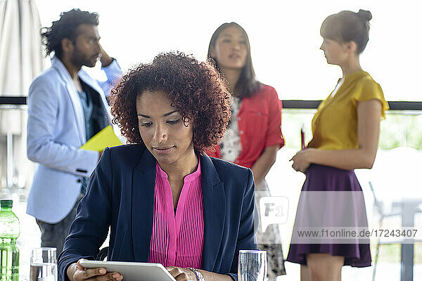 Geschäftsfrau nutzt digitales Tablet mit Kollegen im Büro