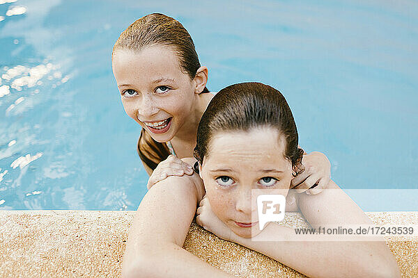 Lächelnde Schwester mit Bruder im Schwimmbad