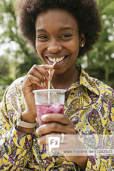 Woman smiling while having smoothie