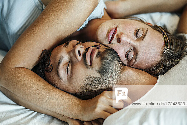 Young couple sleeping together at home