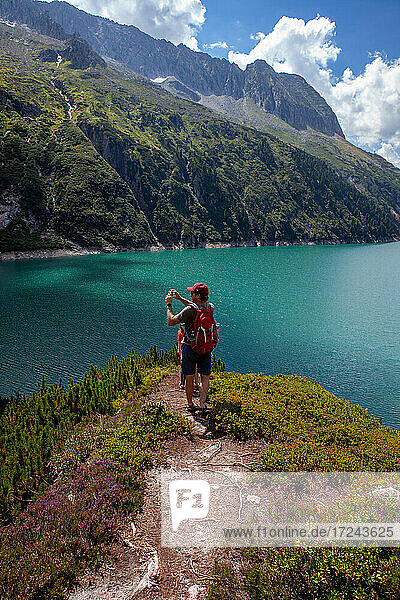 Mann fotografiert seine Töchter  während er auf einem Berg im Zillertal  Österreich  steht