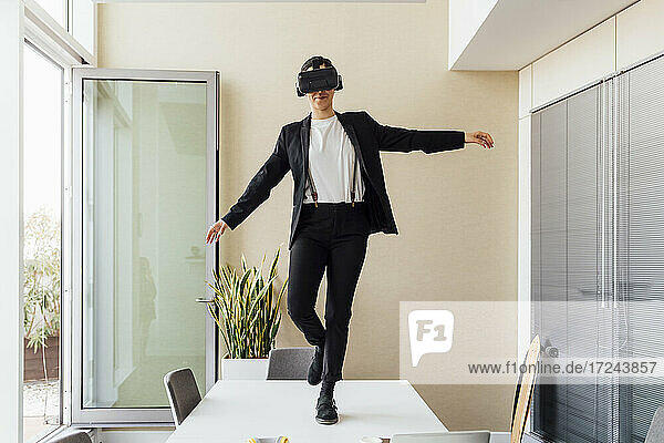 Geschäftsfrau mit Virtual-Reality-Headset auf dem Schreibtisch im Büro