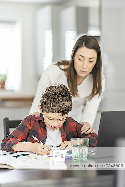 Mutter hilft ihrem Sohn beim Lernen zu Hause