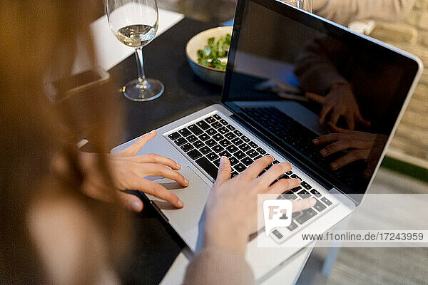Frau mit Laptop im Restaurant