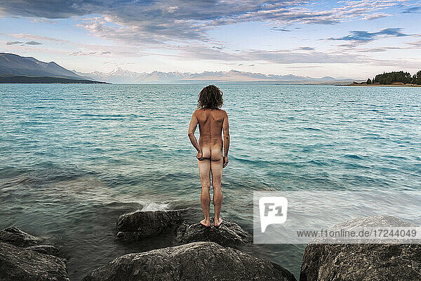 Neuseeland  Canterbury  Rückansicht eines nackten Mannes mit Blick auf den Lake Pukaki bei Sonnenuntergang