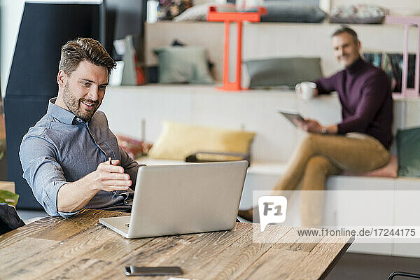 Geschäftsleute diskutieren über Laptop auf Tisch am Arbeitsplatz