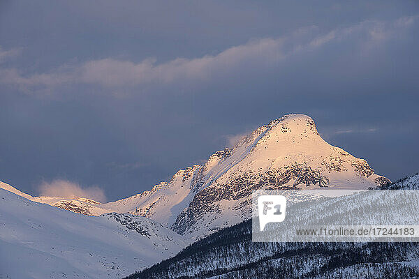 Norwegen  Tromso  Schneebedeckter Berggipfel im Licht des Sonnenaufgangs