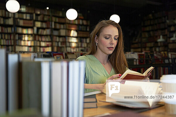 Junge Frau liest ein Buch in der Bibliothek