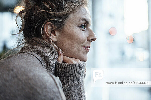 Beautiful woman with hand on chin looking away at cafe