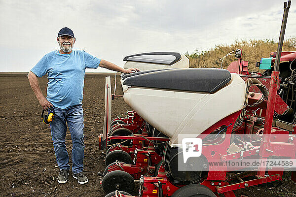 Älterer Landwirt mit Traktor auf dem Bauernhof