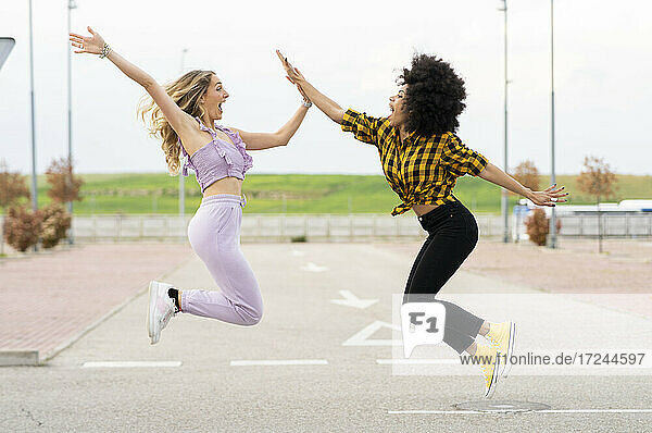 Freundinnen springen auf der Straße im Freien