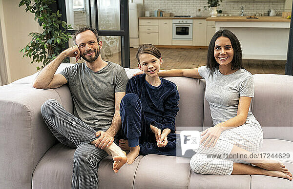 Happy family sitting on sofa in living room at home