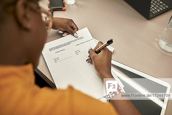 Geschäftsfrau bei der Vertragsunterzeichnung am Schreibtisch im Büro