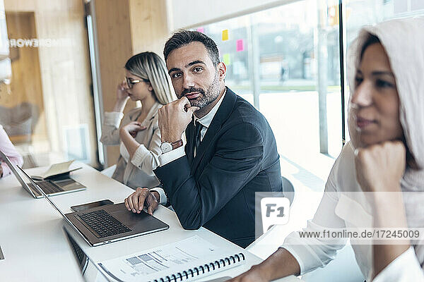 Businessman working with female coworkers in office