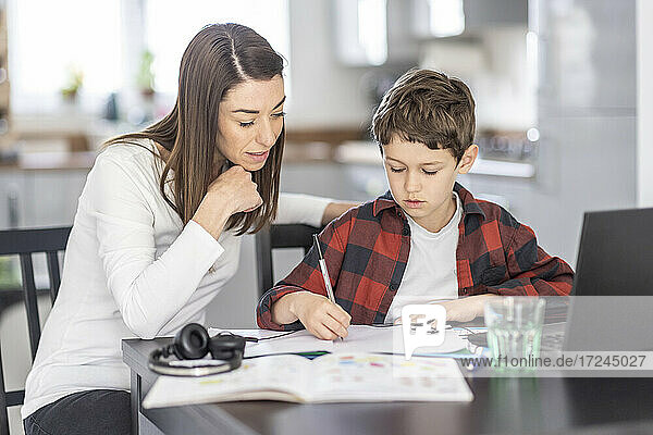 Frau hilft ihrem Sohn beim Lernen zu Hause