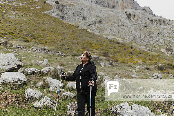 Ältere Frau in Sportkleidung beim Wandern auf einem Berg