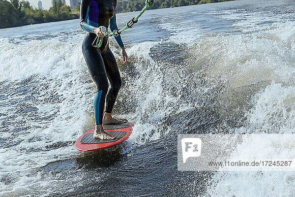 Niedriger Ausschnitt einer Frau beim Wakesurfen im Fluss Moskva