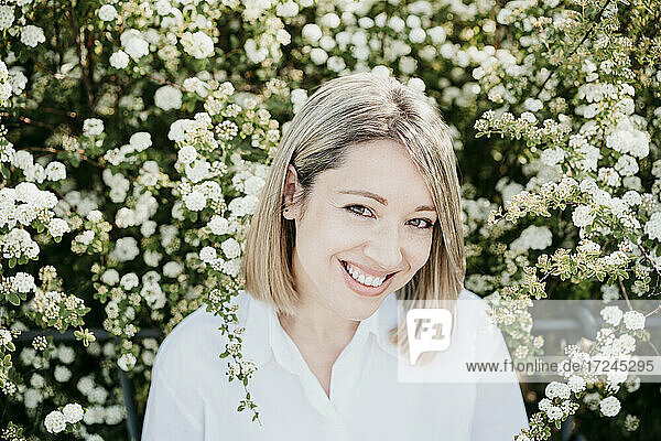 Lächelnde Frau inmitten von weißen Blumen